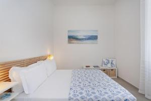 ein weißes Schlafzimmer mit einem Bett und einem Gemälde an der Wand in der Unterkunft In Fondo al Mar by Wonderful Italy in Santa Margherita Ligure