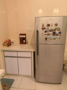 uma cozinha com um frigorífico de aço inoxidável e um balcão em Modern COZY HOUSE 3 ROOM 6PAX@ ALMA JUSCO.BM em Bukit Mertajam