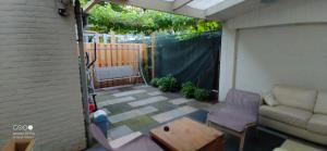 a small patio with a couch and a table at Cozy house in Weert in Weert +9 photos