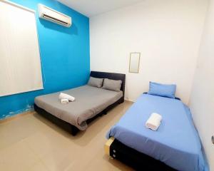 Duas camas num quarto com paredes azuis e brancas em Modern COZY HOUSE 3 ROOM 6PAX@ ALMA JUSCO.BM em Bukit Mertajam