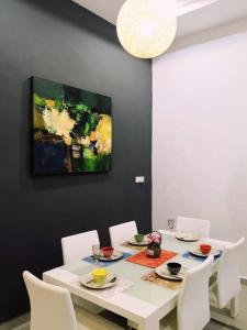 uma sala de jantar com uma mesa branca e cadeiras brancas em Modern COZY HOUSE 3 ROOM 6PAX@ ALMA JUSCO.BM em Bukit Mertajam