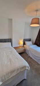 - une chambre avec deux lits, une table et une lampe dans l'établissement Home in Monkstown, à Monkstown