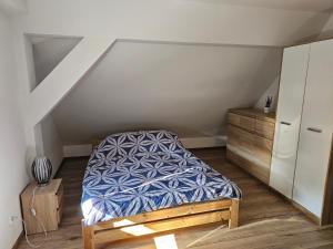 a bedroom with a bed and a dresser in a attic at Julka in Kopalino