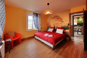 a bedroom with a red bed and a dining room at Granit'Home in Gérardmer
