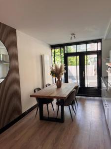 a dining room table with a vase of flowers on it at Casa Xabia in Zaandam