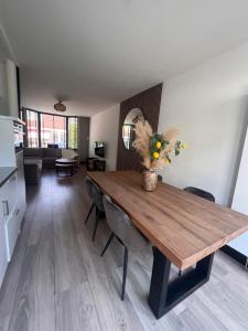 a kitchen and living room with a wooden dining table at Casa Xabia in Zaandam