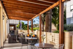 an outdoor patio with two tables and chairs at Kapetanios Limassol Hotel in Limassol