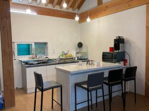 a kitchen with a large island with chairs around it at Guesthouse Comfort Place in Buan
