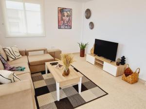 un soggiorno con un divano e una TV di Rooftop Las Vistas, 2 bedrooms First Line a Los Cristianos