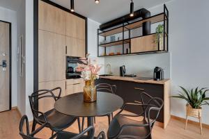 a kitchen and dining room with a table and chairs at Downtown Apartments Garnizon in Gdańsk