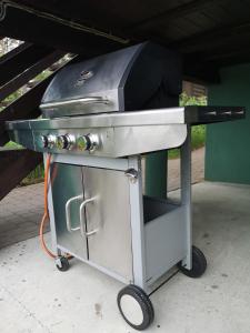a grill sitting on a cart next to a building at Domek pod lasem podlaskie in Moszczona Pańska