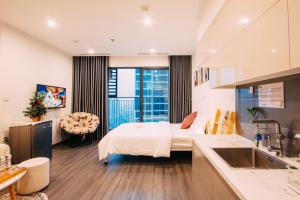 une chambre d'hôtel avec un lit et une cuisine dans l'établissement Apartment 1BR-FL24th-R105 Building-Vinhomes Ocean Park, à Hanoï