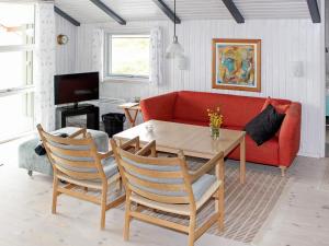 sala de estar con sofá rojo y mesa en 6 person holiday home in Vejers Strand en Vejers Strand