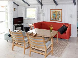 a living room with a red couch and a table at 6 person holiday home in Vejers Strand in Vejers Strand