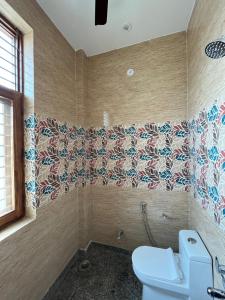 baño con aseo y azulejos en la pared en SRH HOTEL, en Greater Noida