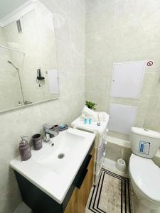 a bathroom with a white sink and a toilet at Гранд Чемпион in Astana