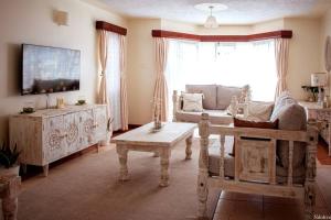 a living room with a couch and a table at Warm & Cozy 2-Br Apartment. 10 mins from City Centre in Nairobi