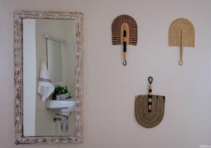 a mirror and a sink in a bathroom at Warm & Cozy 2-Br Apartment. 10 mins from City Centre in Nairobi