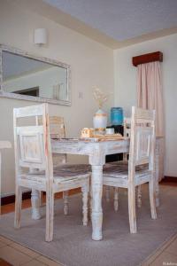 a dining room table with two chairs and a mirror at Warm & Cozy 2-Br Apartment. 10 mins from City Centre in Nairobi