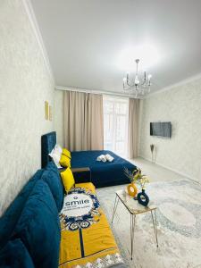 a bedroom with a blue bed and a couch at Гранд Чемпион in Astana
