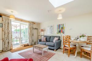 a living room with a couch and a table at Hop Cottage in East Dean