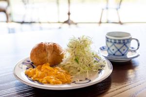 un plato de comida y una taza de café sobre una mesa en B&B Retreat志摩, en Shima