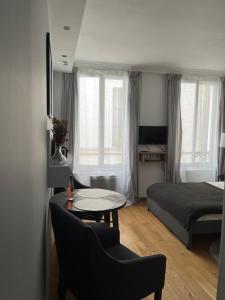 uma sala de estar com uma cama e uma mesa e um quarto em MaisonZen em Paris