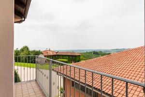einen Balkon mit Metallgeländer und ein Haus in der Unterkunft CASA TILDE Barbaresco in Barbaresco