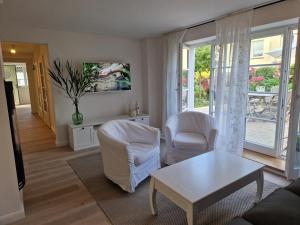 - un salon avec un canapé, des chaises et une table dans l'établissement Ferienwohnung Düne mit Kamin und 2 Bädern in Boltenhagen, à Boltenhagen