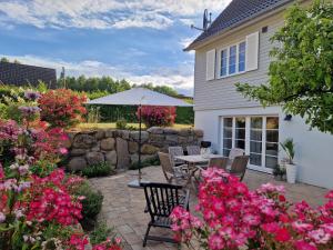 a patio with a table and chairs and flowers at Ferienwohnung Düne mit Kamin und 2 Bädern in Boltenhagen in Boltenhagen