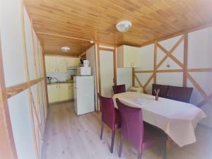 eine Küche und ein Esszimmer mit einem Tisch und lila Stühlen in der Unterkunft Camping familial les chalets d'Uza in Uza