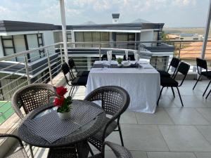 a balcony with a table and chairs on a roof at Estoby Executive guest house in Witbank