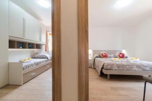 a bedroom with two beds and a mirror at Uncle Leonard's House in Cala Gonone