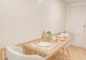 a dining room table with two white plates and chairs at LOUISE - Studio de qualité et très cozy in Saint-Étienne