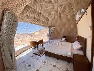 a bedroom with a bed and a view of the desert at Katrina Rum camp in Wadi Rum
