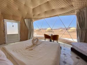 1 dormitorio con cama y ventana grande en Katrina Rum camp, en Wadi Rum