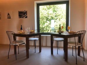 une salle à manger avec deux tables et des chaises ainsi qu'une fenêtre dans l'établissement Tenuta di Ghizzano Resort, à Ghizzano
