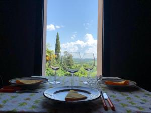 einen Tisch mit Weingläsern auf einem Tisch mit Fenster in der Unterkunft Tenuta di Ghizzano Resort in Ghizzano