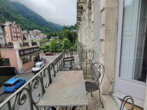 a table on a balcony with a view of a city at Appartement Cauterets, 2 pièces, 2 personnes - FR-1-234-306 in Cauterets