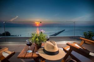 a table with a hat and a view of the ocean at Peraia Rooms in Perea