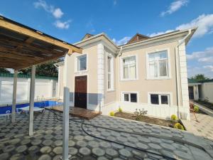 a home with a patio and a house at Yasin White villa in Gabala