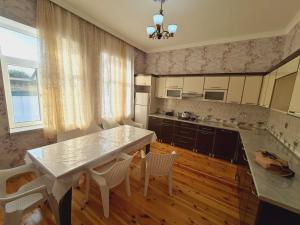 a kitchen with a large white table and chairs at Yasin White villa in Gabala