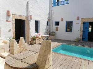 a patio with a pool and a chair and a table at Dar Michèle Djerba in Houmt Souk