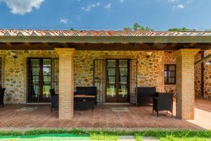 a patio with chairs and a table and a building at Casa Vacanza Il Carpignone 2 in Massa Marittima