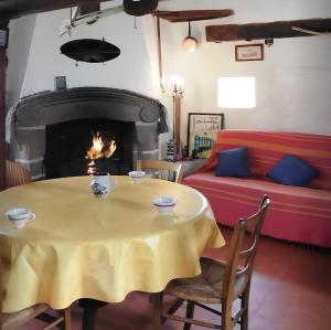 uma sala de estar com uma mesa e uma lareira em Ancien moulin à vent du 19e siècle em Cherrueix