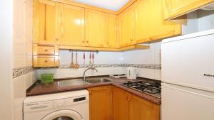 トレビエハにあるApartmento Torrevieja 4248のキッチン(木製キャビネット、シンク、食器洗い機付)