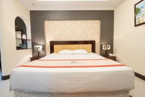 a large white bed in a room with two lamps at Petro House Hotel in Vung Tau