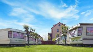 a row of mobile homes parked in a yard at Rodzinne Domki Łeba in Łeba