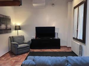 uma sala de estar com um sofá e uma televisão de ecrã plano em Green Villa - CityDoor em Lacchiarella