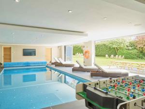 uma grande piscina com duas mesas e uma piscina em Cheltenham's Most Luxurious House em Charlton Kings
